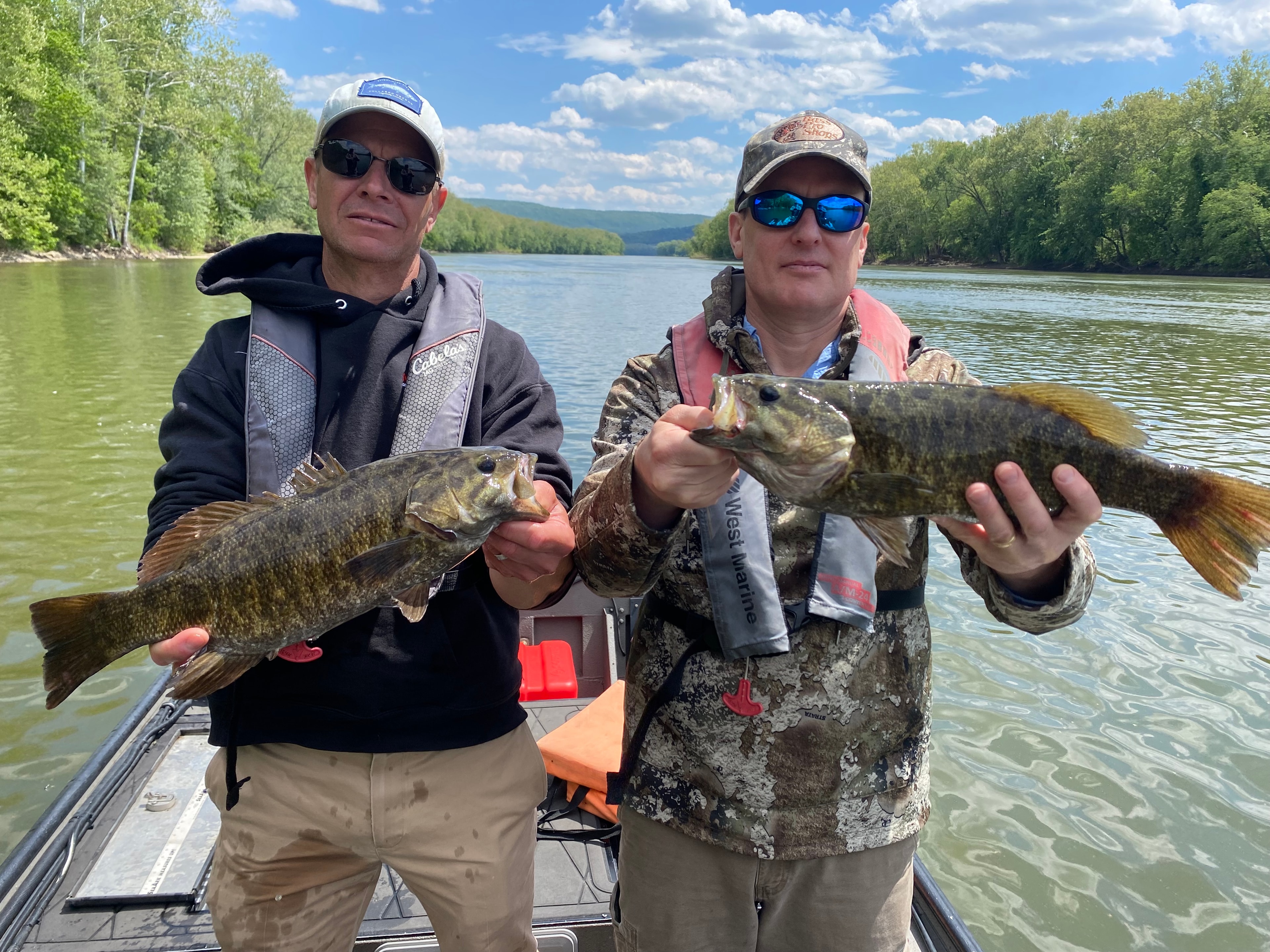 Angler holding a large smallmouth bass on the river