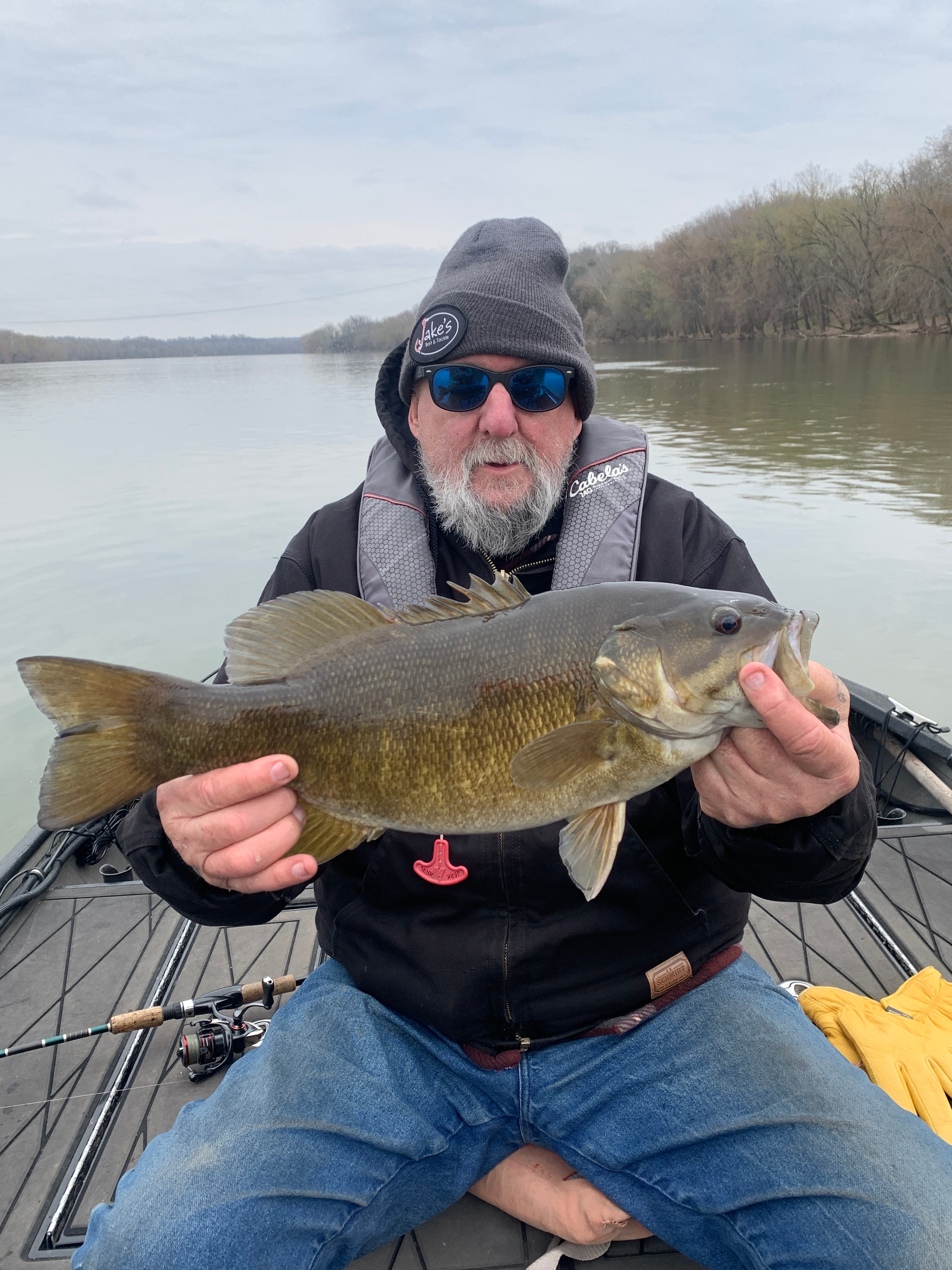 Client with a trophy smallmouth bass on a rainy day