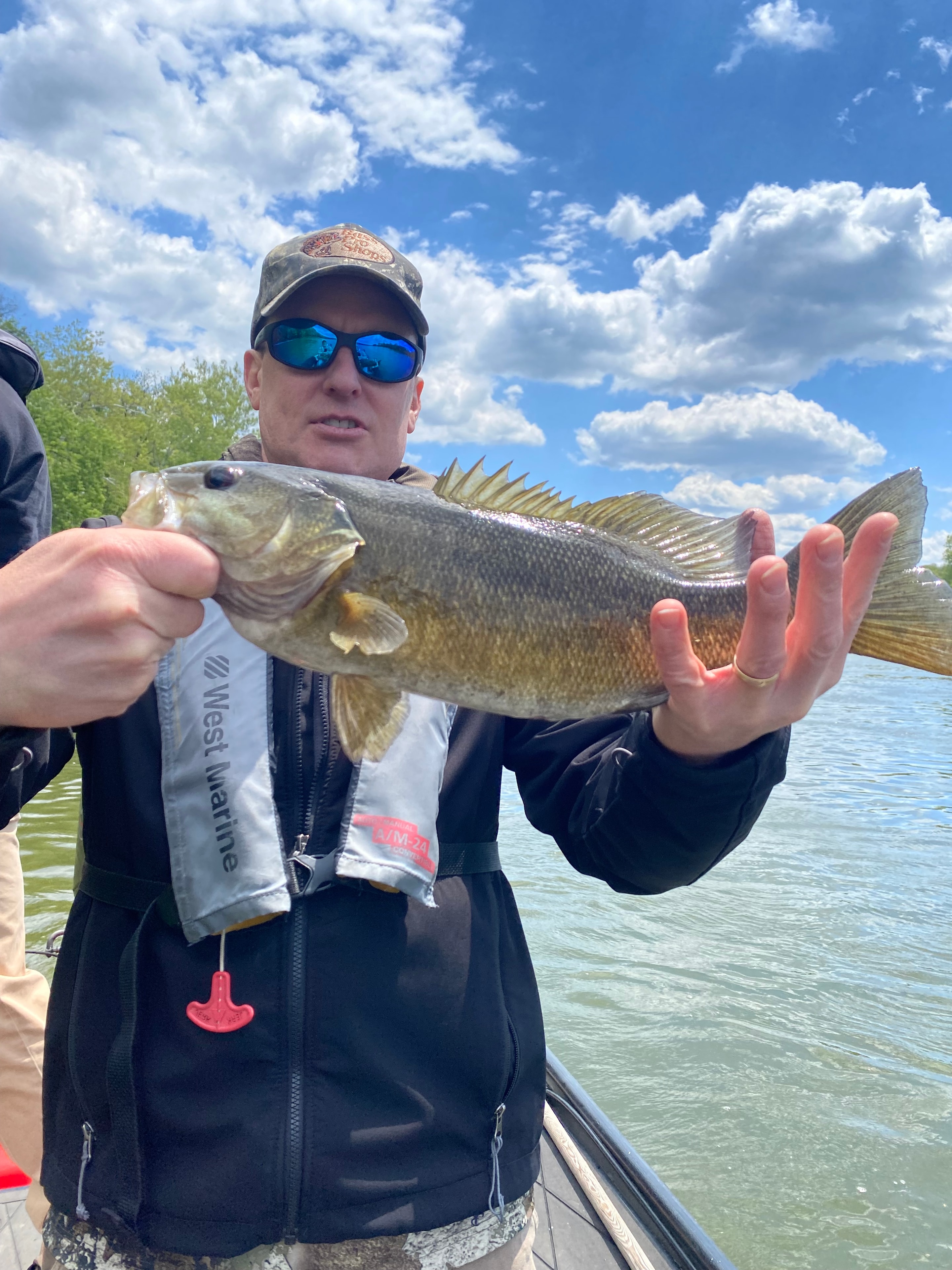 Angler holding two smallmouth bass on the river